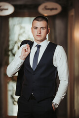 Wall Mural - Vertical shot of a handsome Bosnian Caucasian man wearing a suit, posing indoors