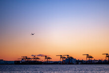 Gantry Crane And Plane In Tokyo Bay At Sunset