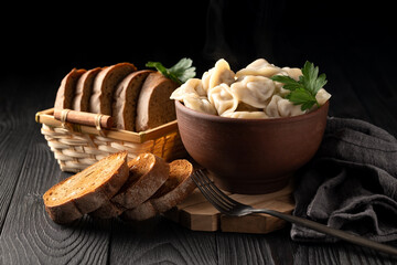 Wall Mural - still life with hot dumplings in a clay bowl and toasted rye bread