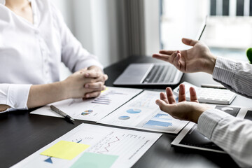 Two businessmen are talking in their office, meeting a marketing plan for solving the problem of falling sales, analyzing the marketing to make sales grow even more. Sales management concept.