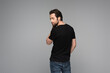 bearded man in black t-shirt posing isolated on grey.