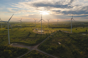 Aerial view of wind turbines or windmills farm field in industry factory. Power, sustainable green clean energy, and environment concept. Nature innovation.