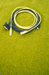 Sticker - Top view shot of a rolled black cable on a green grass surface