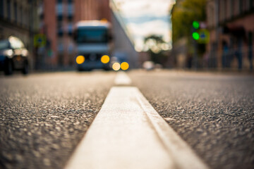 Autumn in the city, truck rides on the green light at the intersection. View from the level of the dividing line