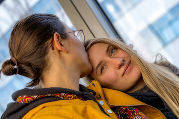 Wall Mural - Lesbian female kissing the forehead of her romantic partner