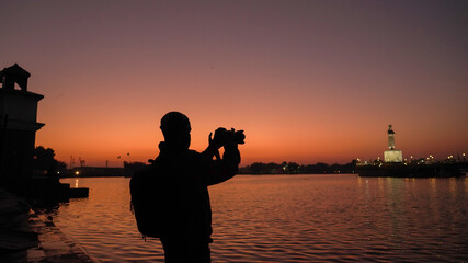 Poster - Silhouette of a photographer capturing the sunset in India, travel photographer shooting the beautiful landscape