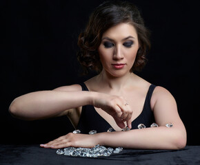 Female at table covered by black velvet with glass stones on it.