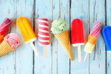 Selection Of Colorful Summer Popsicles And Ice Cream Treats. Overhead View Scattered On A Rustic Blue Background.