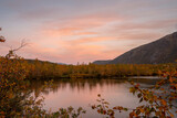 Fototapeta Morze - Sunset on a  mountain lake  in autumn with reflections in the water behind Arctic circle, Kola Peninsula