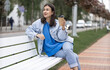 © puhimec - Stylish cheerful girl in casual style enjoys takeaway coffee on a walk.