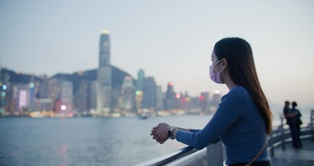 Canvas Print - woman wear face mask and look at the city of Hong Kong