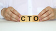 © Valeria - A businessman holds wooden cubes with a word CTO on a white background, with space to copy the text, business concept