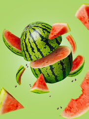 Wall Mural - Ripe and juicy watermelon falling in the air isolated on a pastel green background. Creative food concept. Fresh exotic fruit composition.