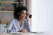 © fizkes - Smiling young African American woman listen to audio voice message on modern smartphone gadget. Happy millennial mixed race female use cellphone talk speak on loudspeaker. Technology concept.