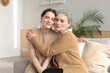 © ty - Portrait of old mother and mature daughter hugging at home. Happy senior mom and adult daughter embracing with love on sofa.