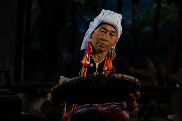 An old woman selecting coffee beans at a coffee roasting factory in Chiang Mai, Thailand.