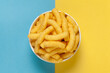 Close up of Cheese Potato Puff Snacks sticks, Popular Ready to eat crunchy and puffed snacks sticks  cheesy salty pale-yellow color over Blue-Yellow background