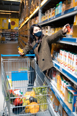 Wall Mural - woman choosing juice at grocery store