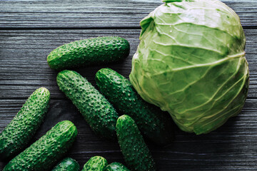 Wall Mural - Cabbage with cucumbers top view on a background of wooden boards.