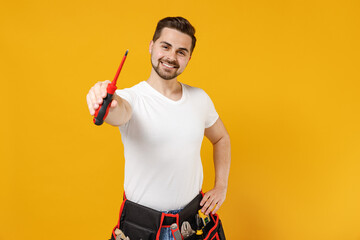 Young smiling excited confident employee handyman man in white t-shirt give screw instrument tool isolated on yellow background Instruments accessories renovation apartment room Repair home concept.