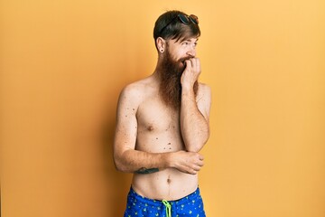 Sticker - Redhead man with long beard wearing swimsuit and sunglasses looking stressed and nervous with hands on mouth biting nails. anxiety problem.