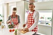 © Krakenimages.com - Senior caucasian couple smiling happy cooking at the kitchen.