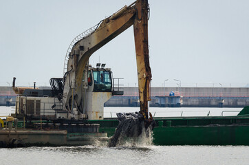 CONSTRUCTION WORK IN A SEAPORT - Excavator on a floating work platform 