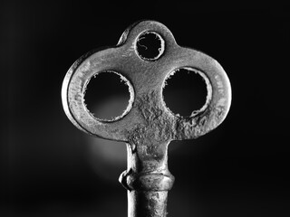 Sticker - Black and white shot of an old key for a door on a black background