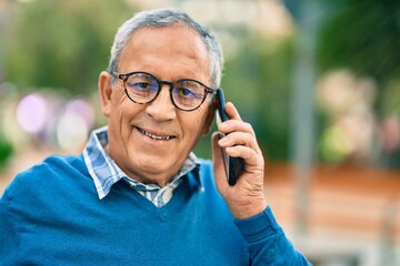 Wall Mural - senior grey-haired man smiling happy talking on the smartphone at the city.