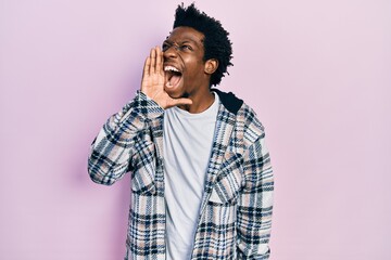 Poster - Young african american man wearing casual clothes shouting and screaming loud to side with hand on mouth. communication concept.