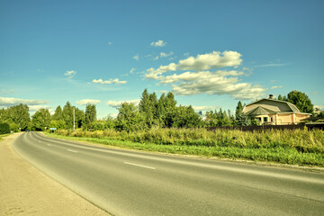 Asphalt road among hills and green grass.