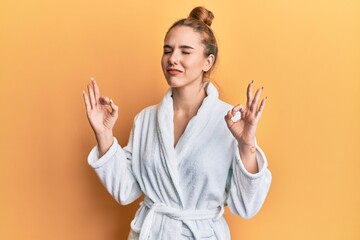 Canvas Print - Young blonde woman wearing bathrobe relax and smiling with eyes closed doing meditation gesture with fingers. yoga concept.