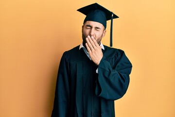 Sticker - Young hispanic man wearing graduation cap and ceremony robe bored yawning tired covering mouth with hand. restless and sleepiness.