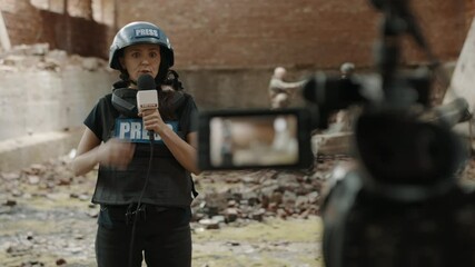 Wall Mural - POV Camera view, female war journalist correspondent wearing bulletproof vest and helmet reporting live near destroyed building