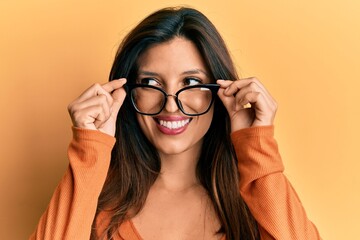 Wall Mural - Beautiful hispanic woman wearing glasses smiling looking to the side and staring away thinking.