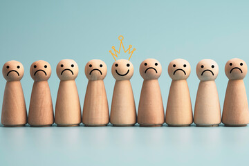Poster - Smiley face  on wooden figure among sadness wooden figure on blue background , Emotion select mindset and happiness concept.