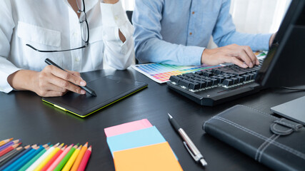 Poster - graphic designer team working on web design using color swatches editing artwork using tablet and a 