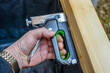 Close up of a carpenter using a brad nailer staple gun into wooden boards to repair  the inside covering of a. box