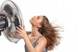 Young woman cooling down with electric fan