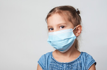 Wall Mural - Little girl wearing face mask on a white background