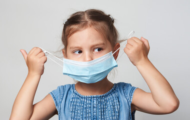 Wall Mural - Little girl wearing face mask on a white background