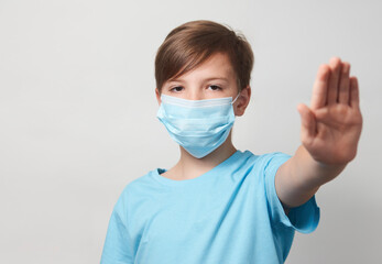 Wall Mural - School boy with face mask on white background