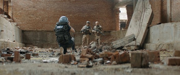 Wall Mural - Two soldiers posing for female war journalist inside destroyed building