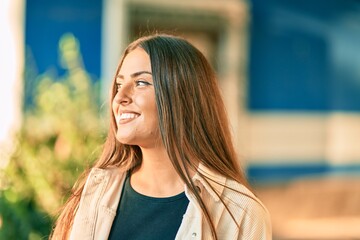 Wall Mural - Young hispanic girl smiling happy standing at the city.