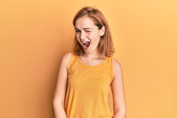 Canvas Print - Young caucasian woman wearing casual style with sleeveless shirt winking looking at the camera with sexy expression, cheerful and happy face.