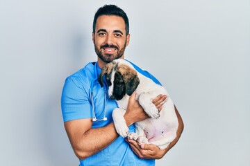 Sticker - Handsome hispanic veterinary man with beard checking dog health smiling with a happy and cool smile on face. showing teeth.