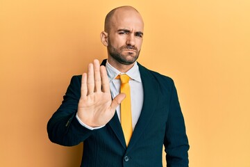 Sticker - Young hispanic man wearing business suit and tie doing stop sing with palm of the hand. warning expression with negative and serious gesture on the face.