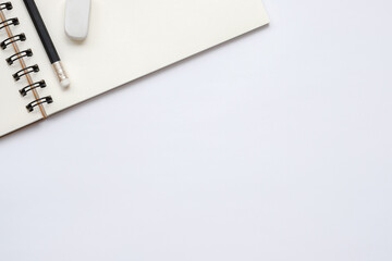 Wall Mural - open blank notebook with pencil and eraser on white background, flat lay, top view of workspace, cop