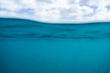 Wall Mural - Blue water and a cloudy sky above the surface