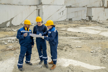 One of modern builders pointing at sketch of construction during teamwork